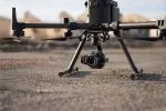 Dron profesional con cámara sobre terreno desértico